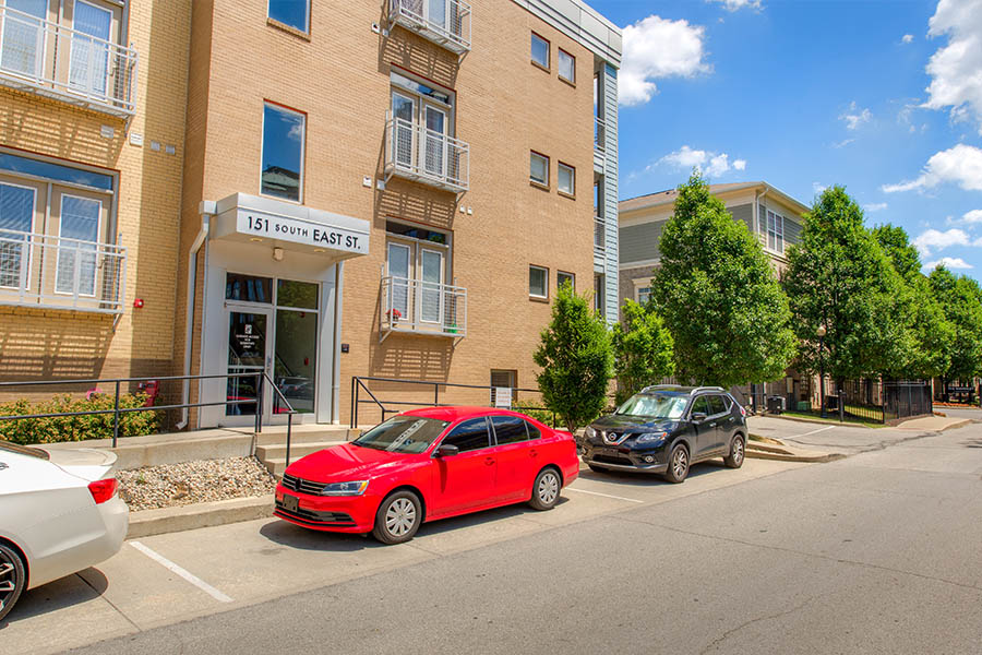 Exterior of Waverly Apartments' residential parking with cars.