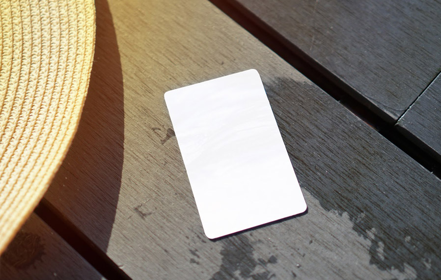 Don't forget your pool pass to to take a refreshing swim at SOMO Flats. Summer hat and key card on a deck floor.