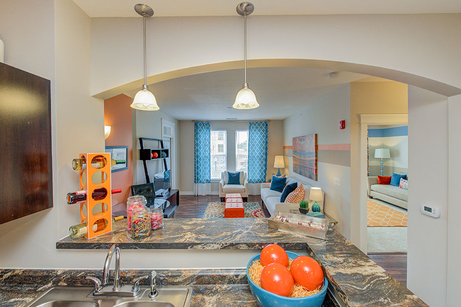 Pendant lights hanging in a kitchen and living room at One One Six Apartments